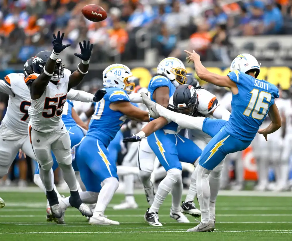 Chargers punter JK Scott (16) barely gets a punt away...