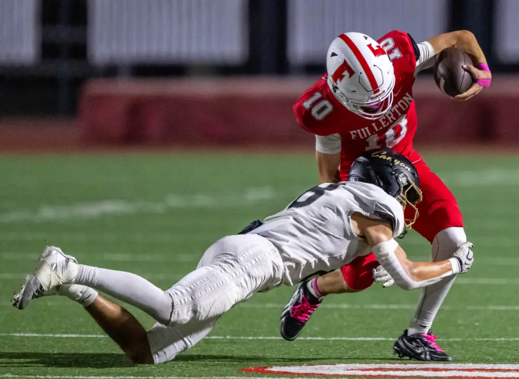 Fullerton quarterback Sergio Andrade (10) breaks a tackle while carrying...