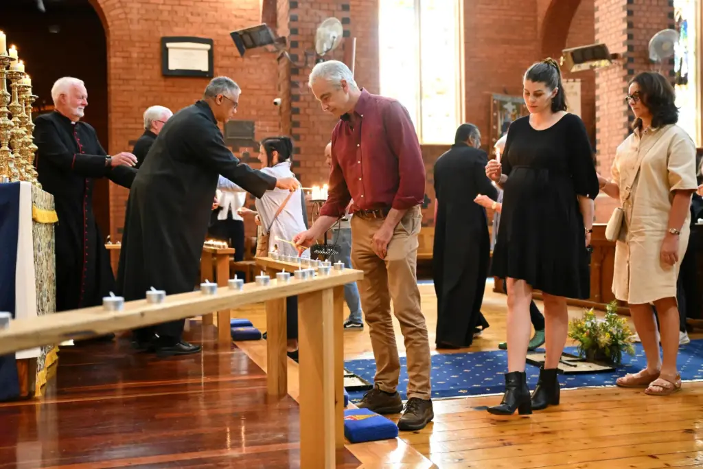 People line up to light a candle during a vigil for Helen Haines.