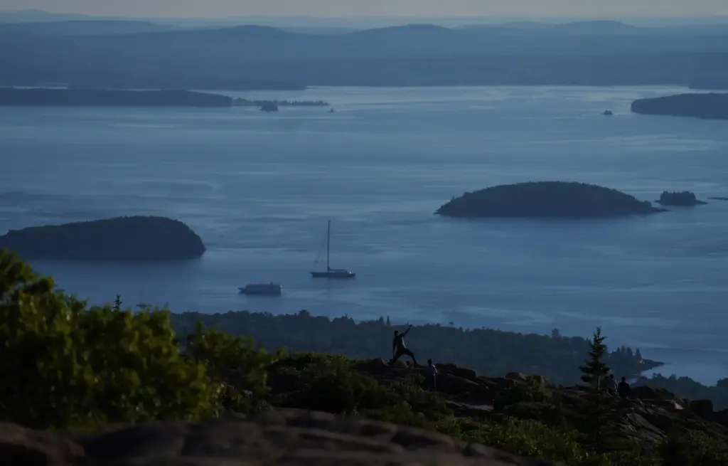 Visitors pose for photos at the summit of Cadillac Mountain...