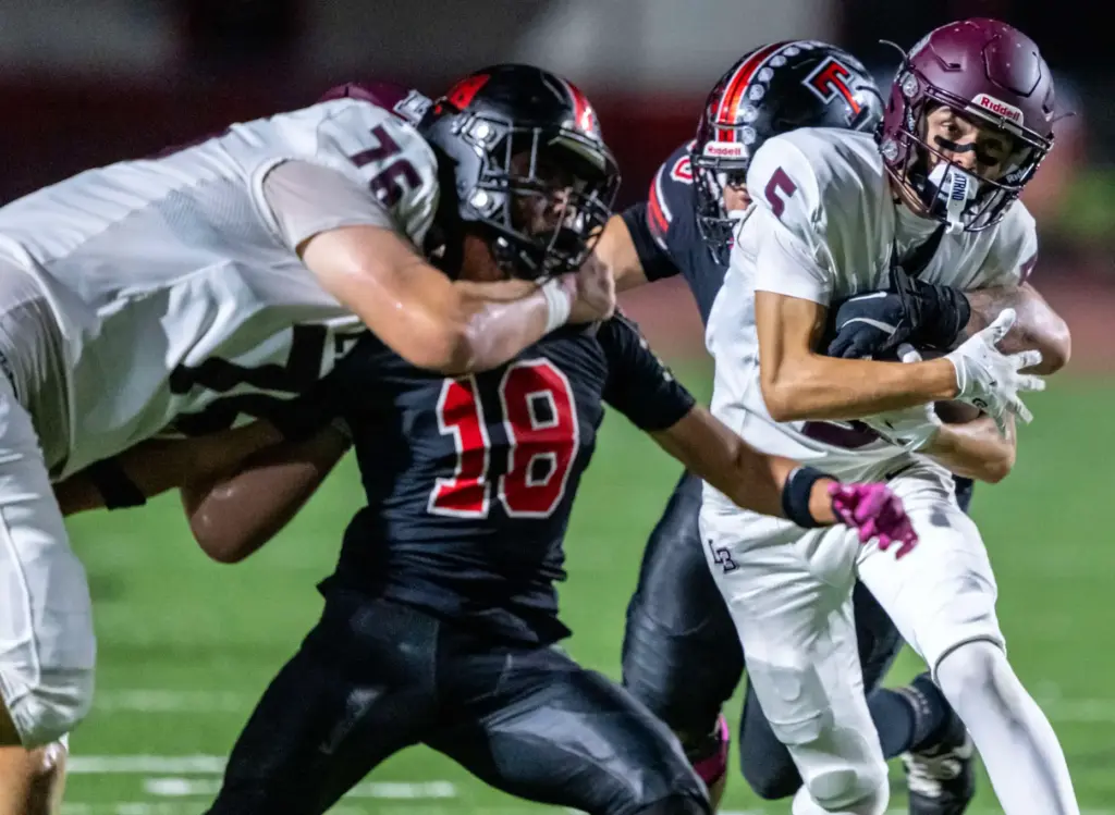 Laguna Beach wide receiver Luca Guzman (5), right, carries the...