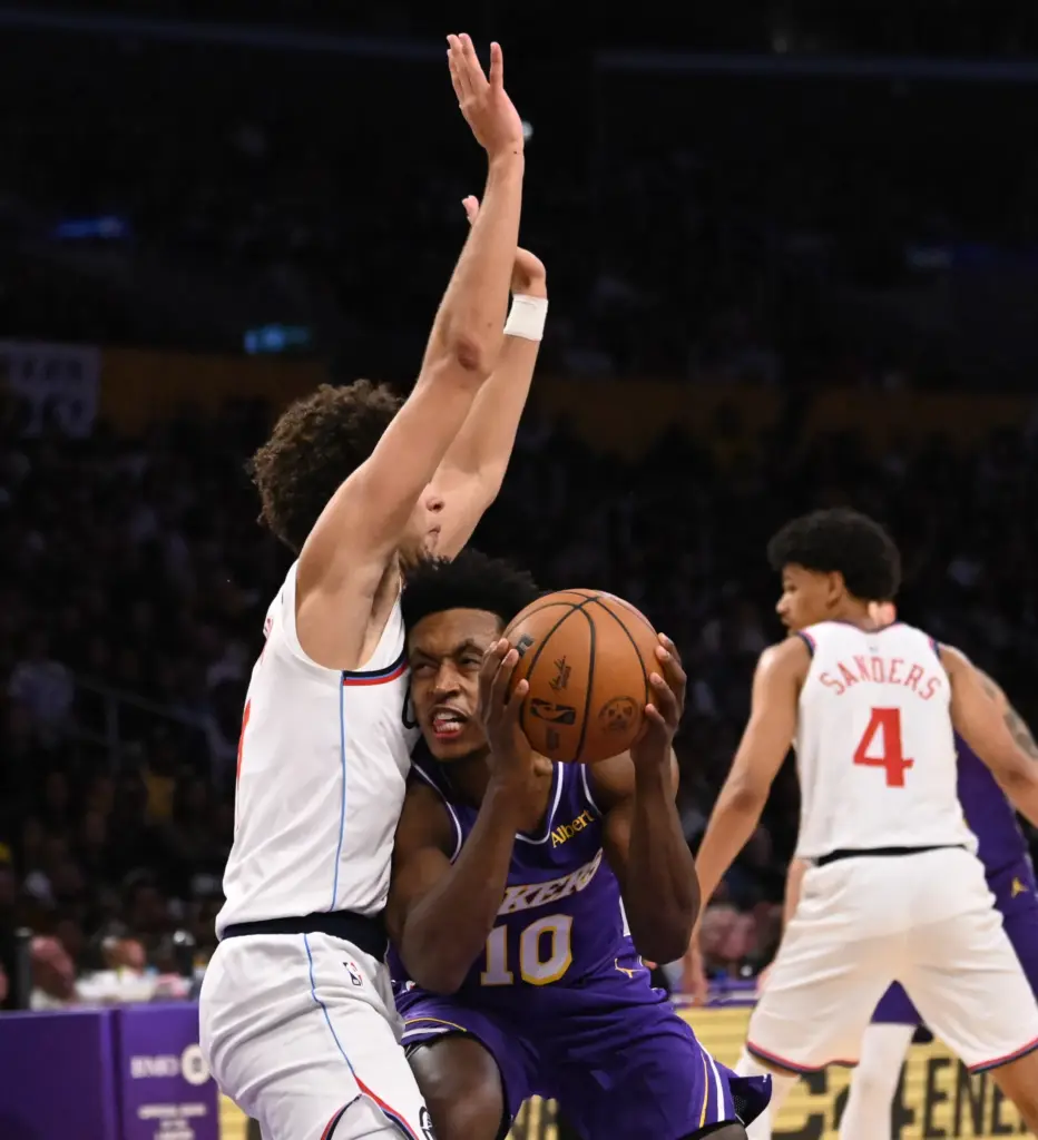 Lakers guard Collin Sexton, right, drives to the basket as...