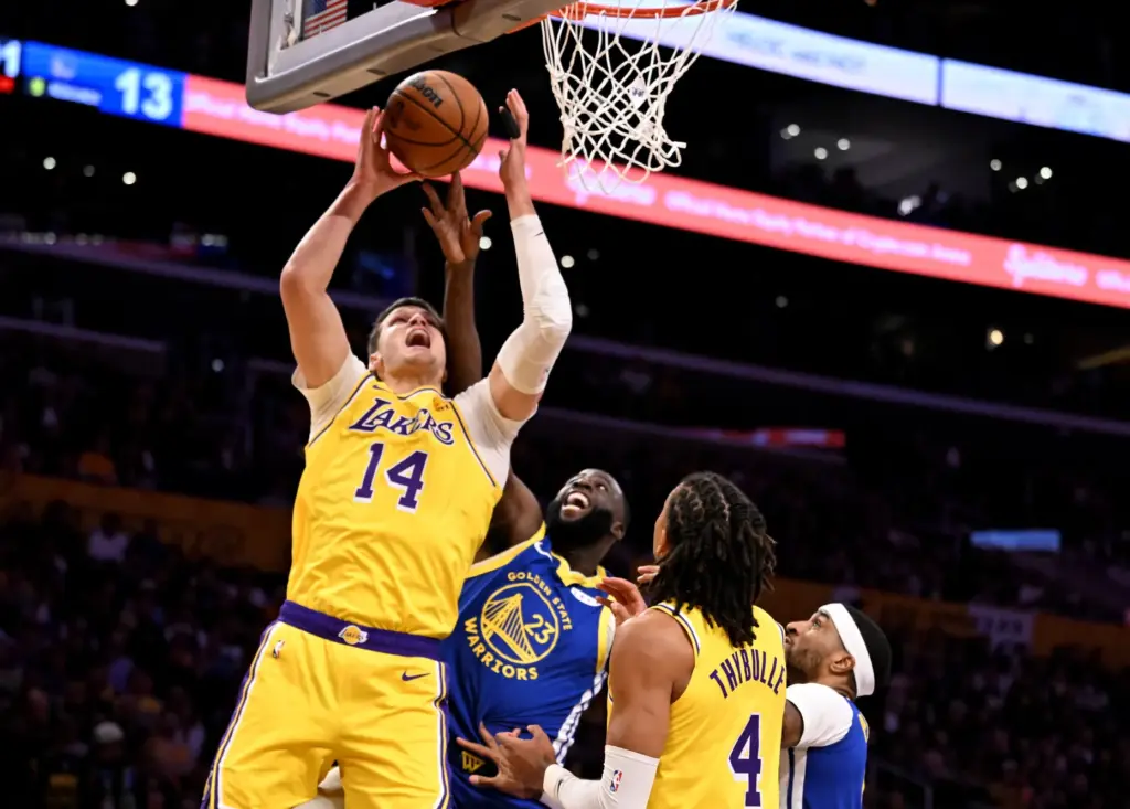 Lakers center Walker Kessler grabs a rebound in front of...