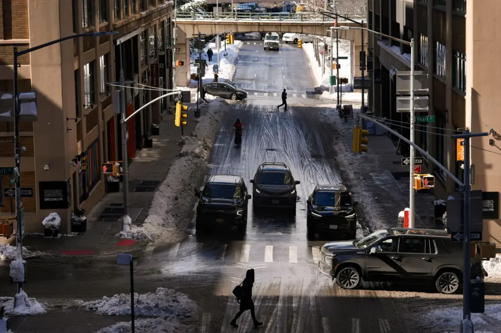 FILE – Pedestrians and cars pass through the Dumbo neighborhood...