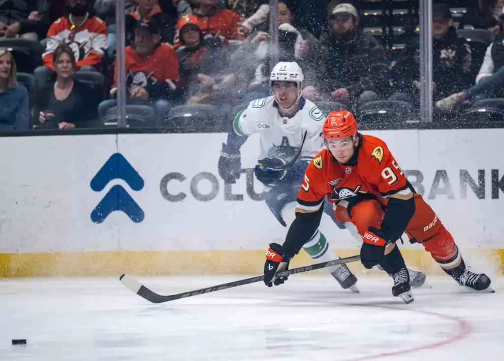The Ducksâ Roger McQueen, right, races for the puck during...