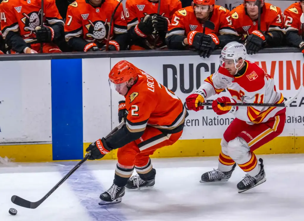 The Ducksâ Jackson LaCombe, left, brings the puck up the...