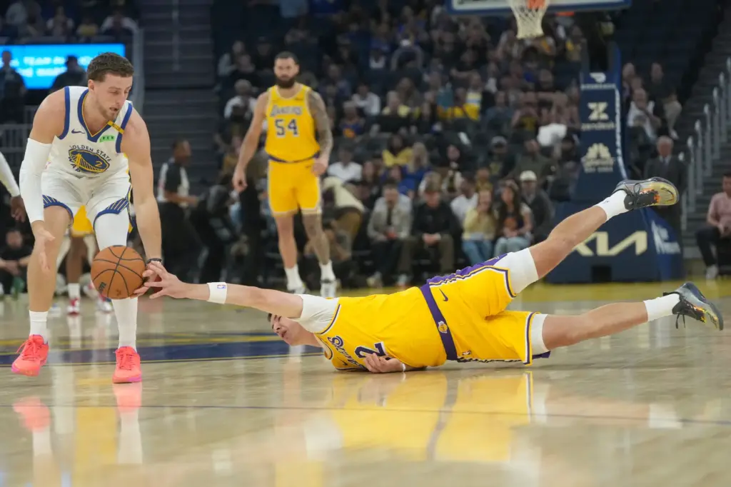 Golden State Warriors guard Brandin Podziemski, left, grabs the ball...