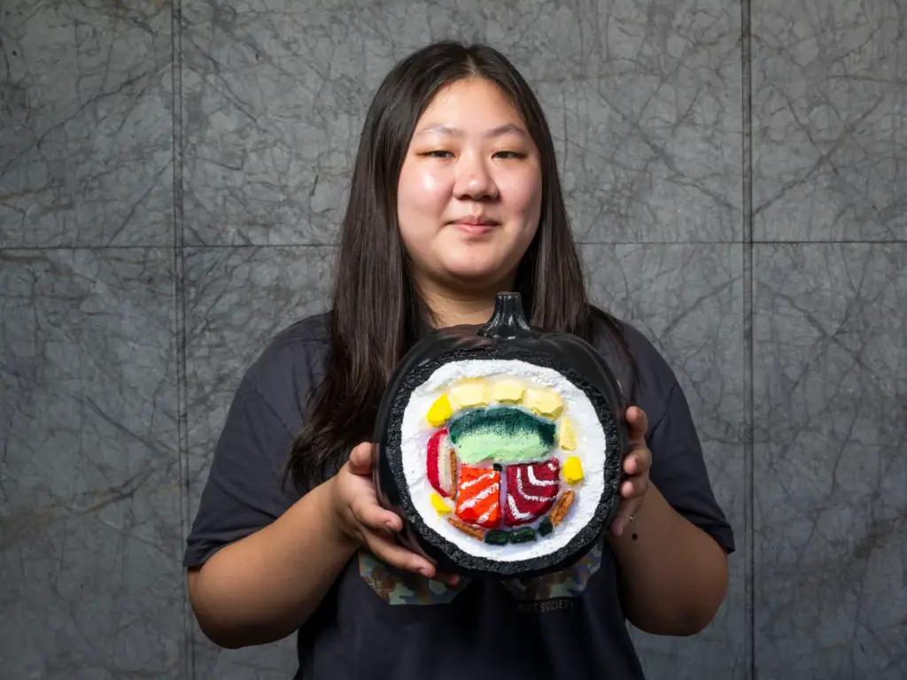 Evelyn Lee holds her pumpkin titled âSushi Rollâ which she...