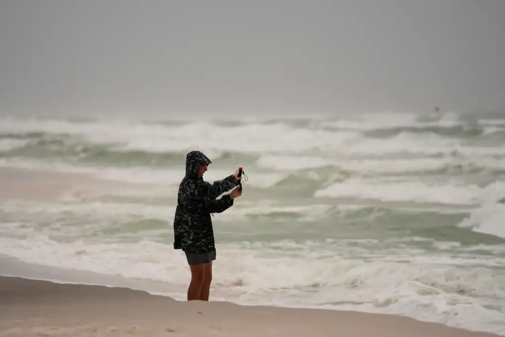 Silas Bowles, of Gulf Breeze, Fla. films the surf as...
