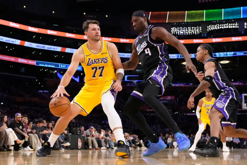 Lakers star Luka Doncic, left, tries to get past Sacramento...