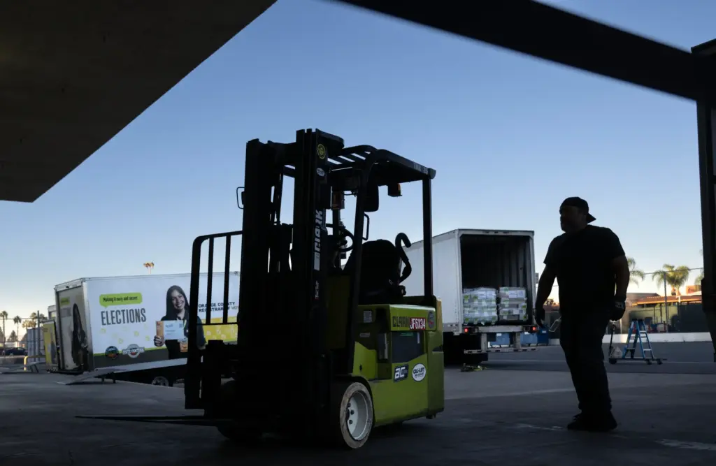 Workers move pallets of ballots — more than 1.9 million...