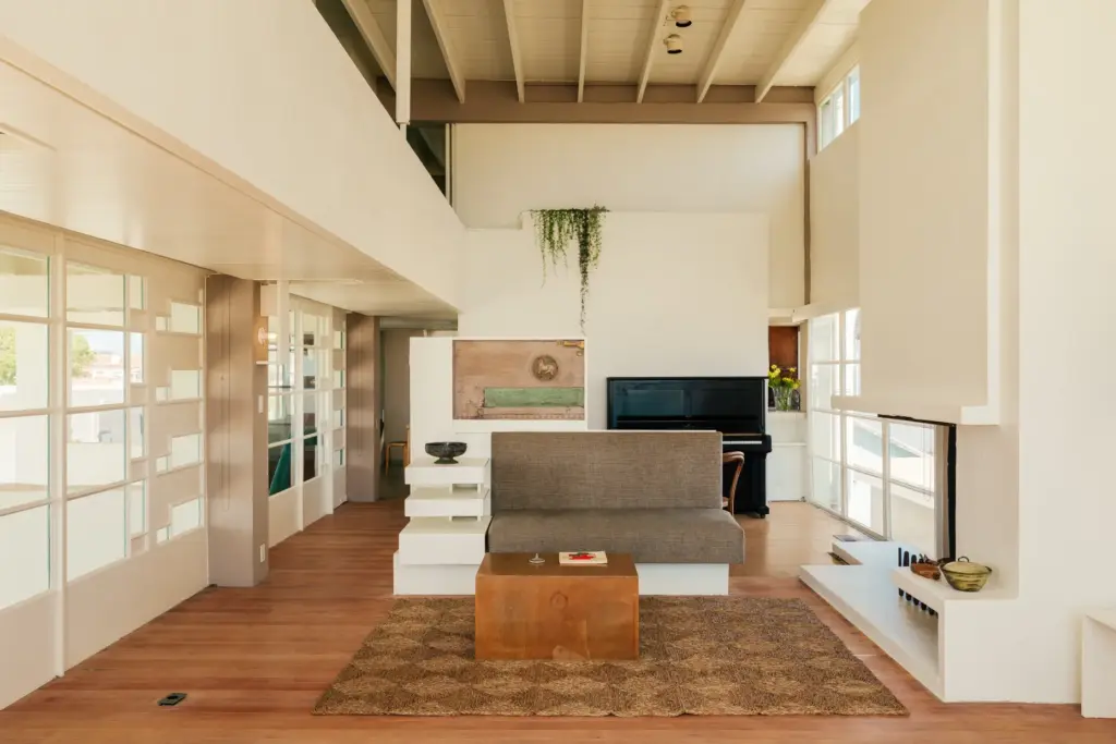 A Schindler-designed built-in sofa and storage unit separates the living...