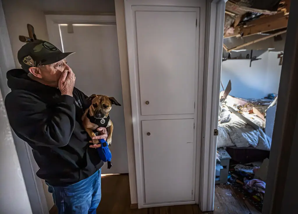 Gary Delgado looks at damage of his home including the...