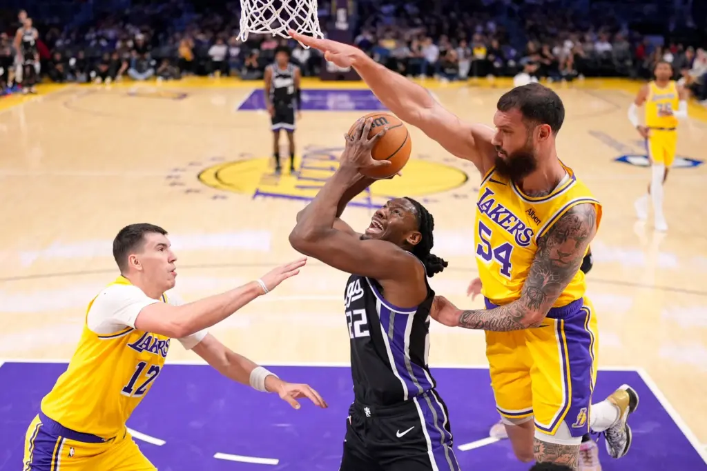 The Sacramento Kings’ Jonathan Mogbo, center, shoots as Lakers forward...