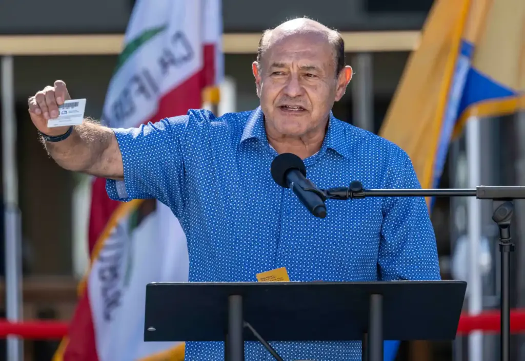Congressman Lou Correa holds up his new Santa Ana library...