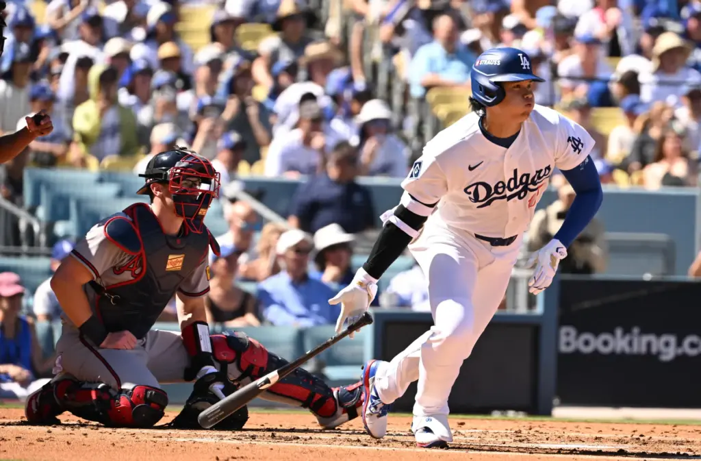 Dodgers star Shohei Ohtani begins to run after hitting a...