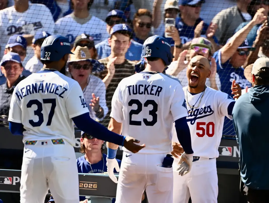 The Dodgers’ Kyle Tucker, center, is greeted by teammate Mookie...