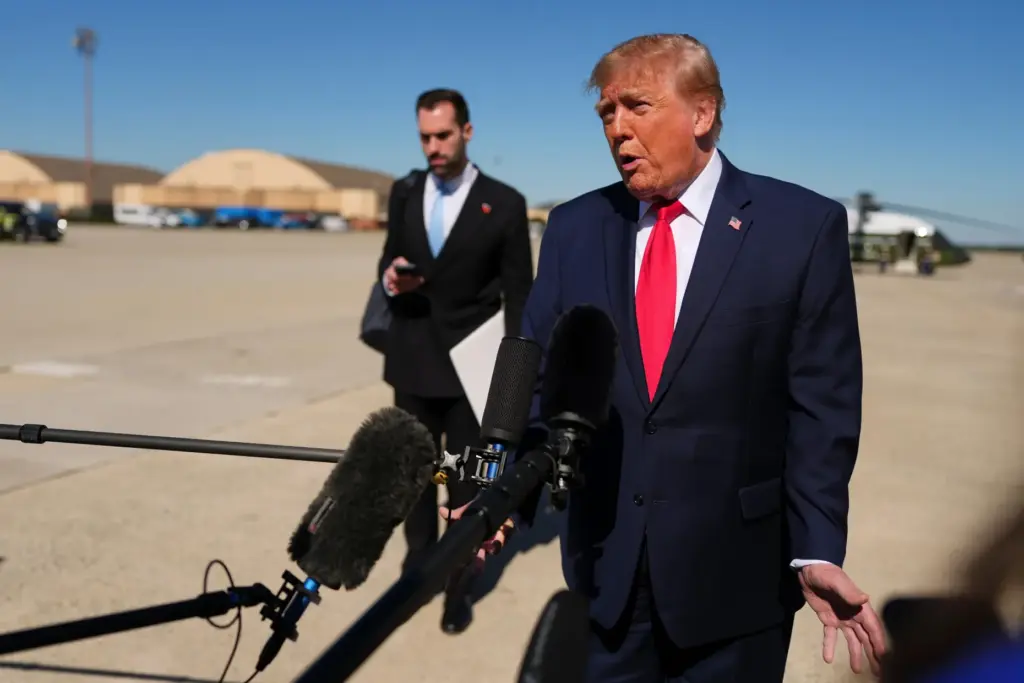 President Donald Trump speaks with reporters before boarding Air Force...