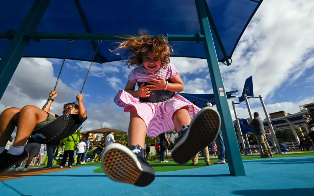 Fisher Derderian, 6, plays on the swings in the improved...