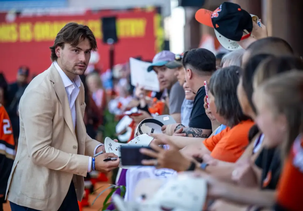 Ducks player Cutter Gauthier signs autographs on the orange carpet...