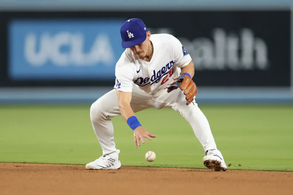 Dodgers second baseman Tommy Edman is unable to field a...