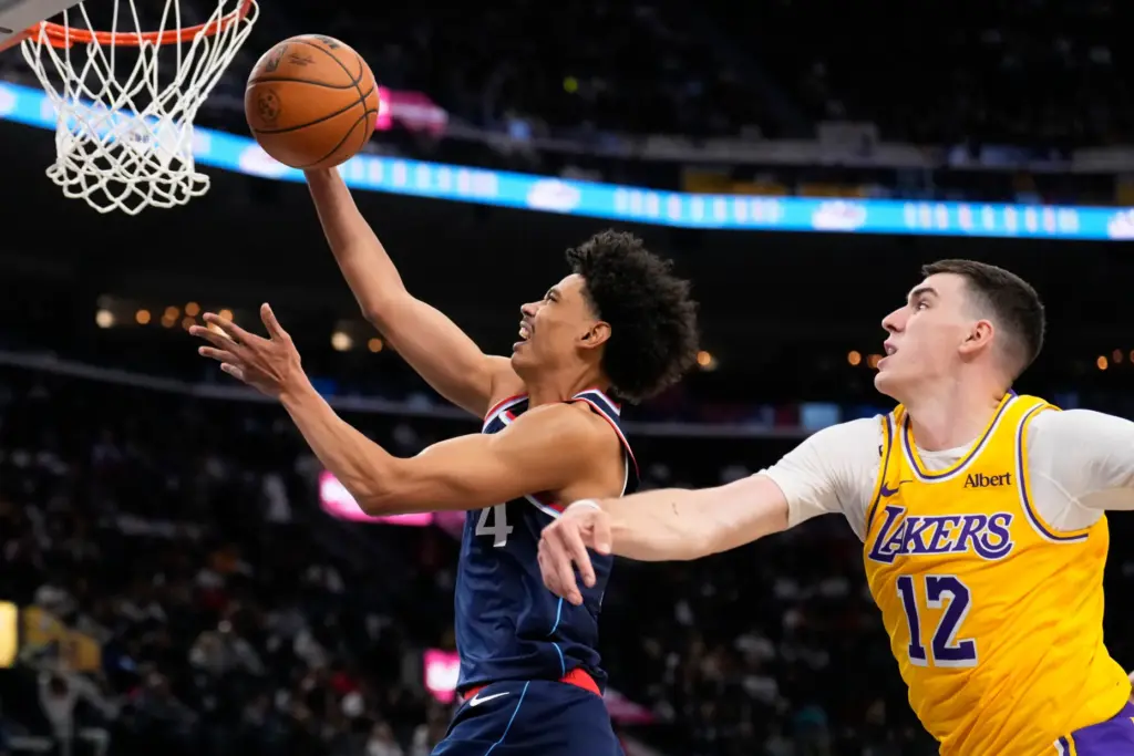 Clippers guard Kobe Sanders, left, shoots as Lakers forward Jake...