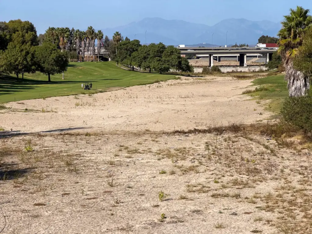 The dry Santa Ana River goes through River View Golf...