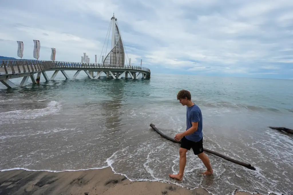 A tourist walks on the beach after the passing of...