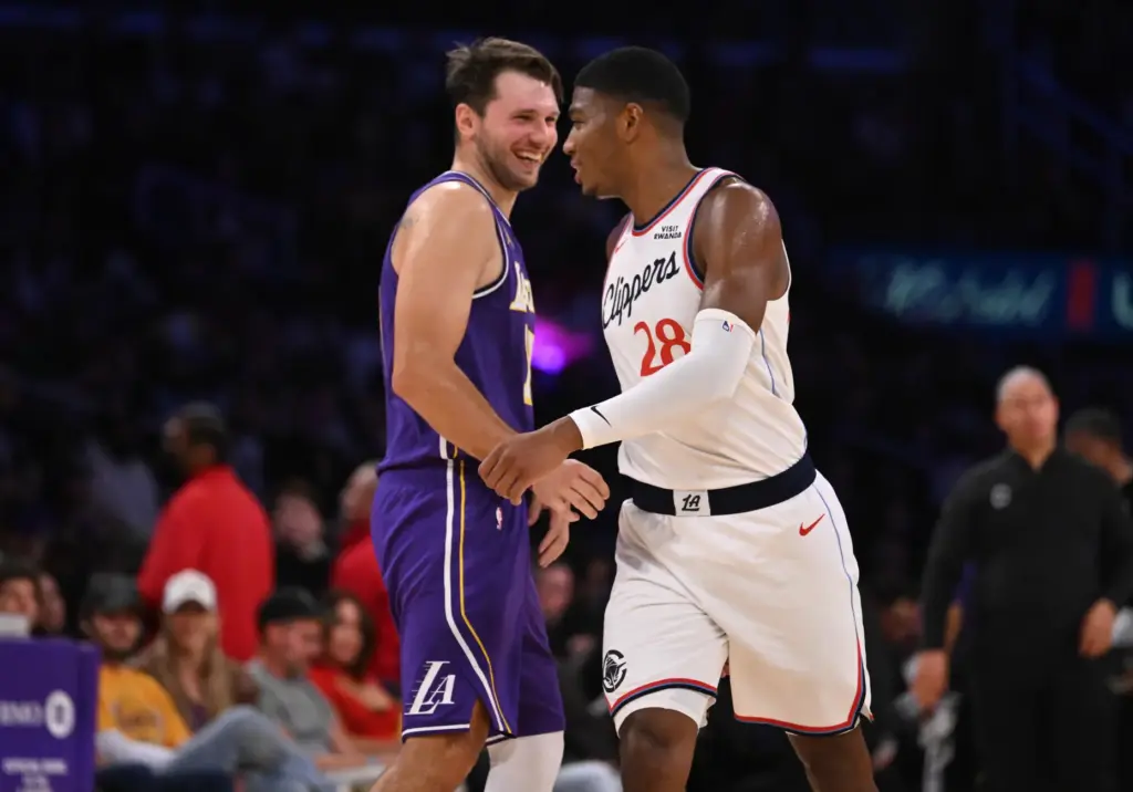 Lakers star Luka Doncic,left, shares a light moment with Clippers...
