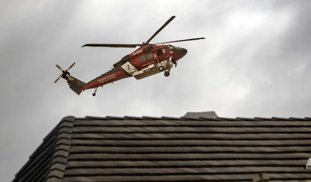 An OCFA chopper hovers near homes on Saturday, October 17,...