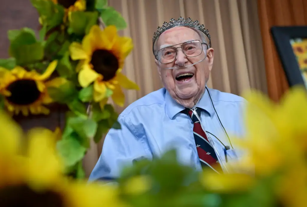 Ernie Maunders, 101, laughs during a joint birthday celebration of...