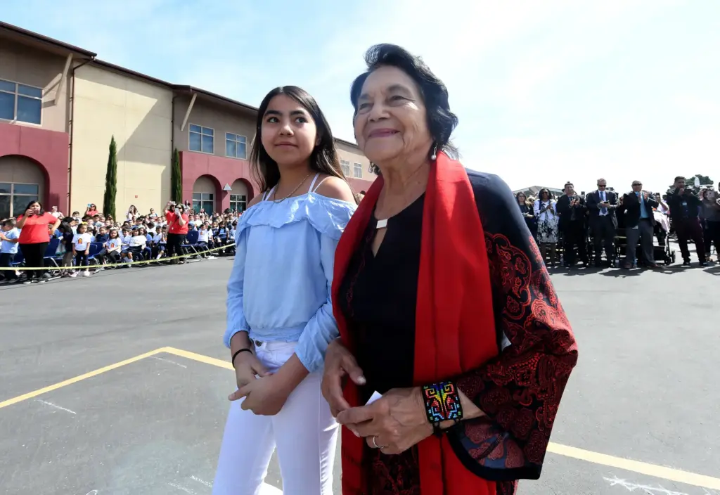 Dolores Huerta, 89, walks to the podium as she is...