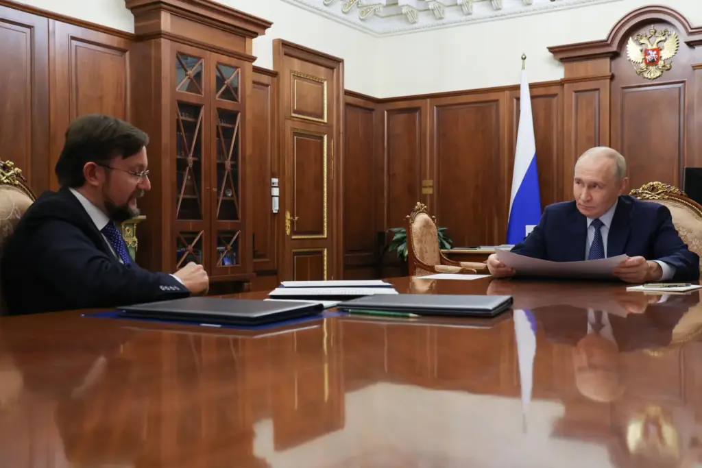 Russian President Vladimir Putin, right, listens to head of the...